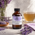 An amber glass bottle of Coffee Corner Cafe Elixir Lavender essential oil or tincture, styled on a marble surface with lavender sprigs, a glass of tea, and dried lavender.